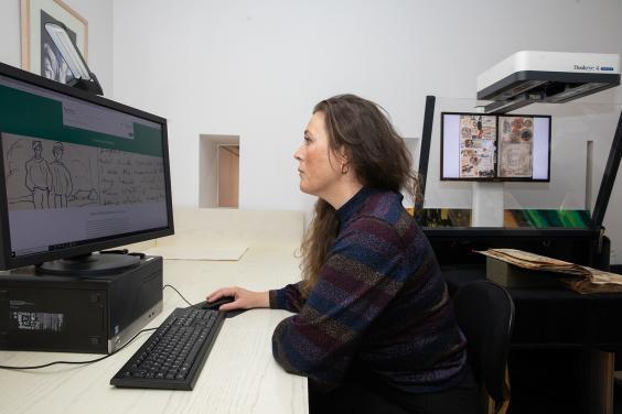 Woman at a computer looking through digitised archives on Source