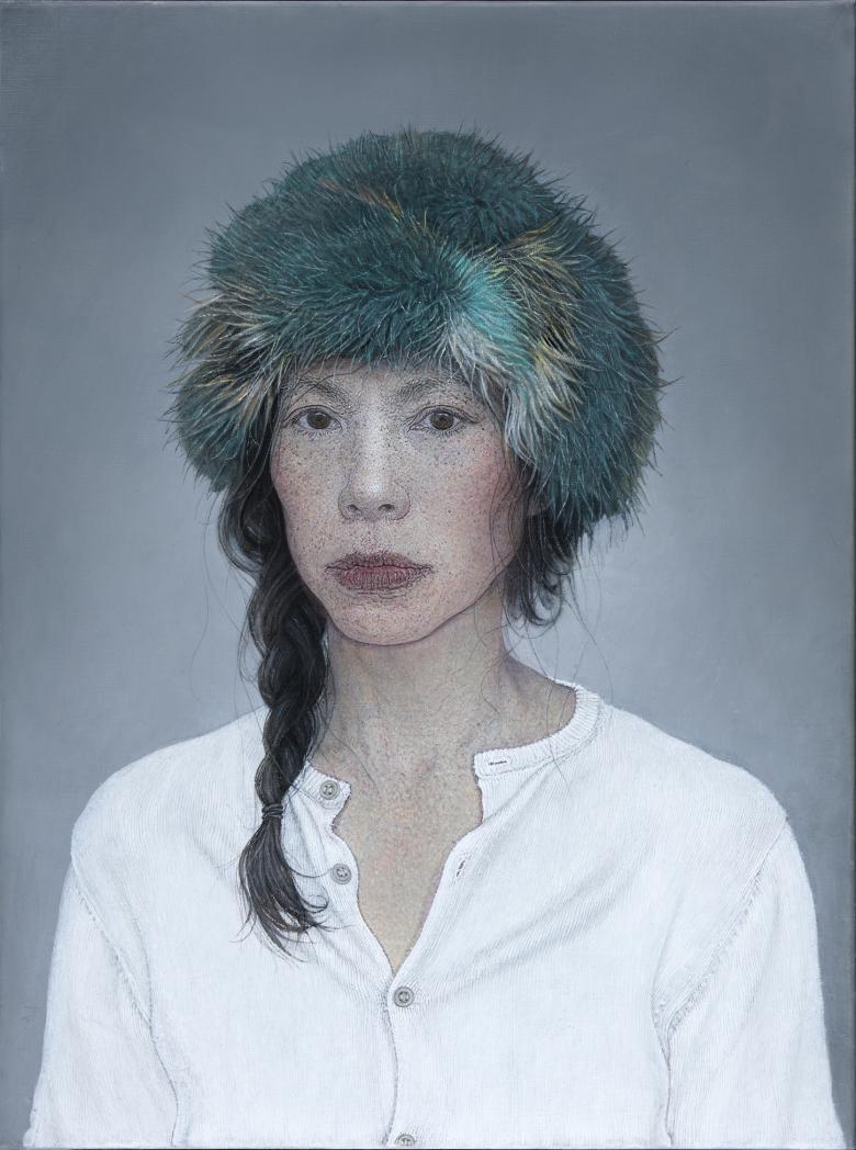 The subject of the portrait wears a white collarless shirt, and has a green fur hat on her head. Her dark hair is in a plait which is over one shoulder, with loose tendrils. She looks directly at the viewer.