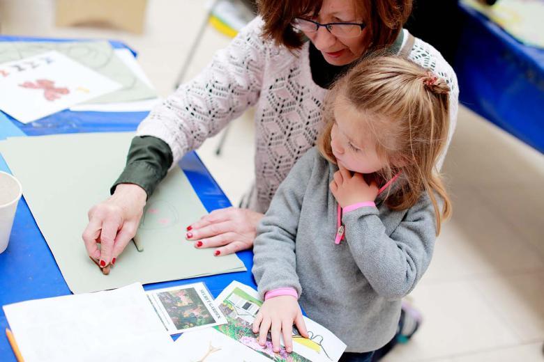 Photo of a woman and child drawing together.