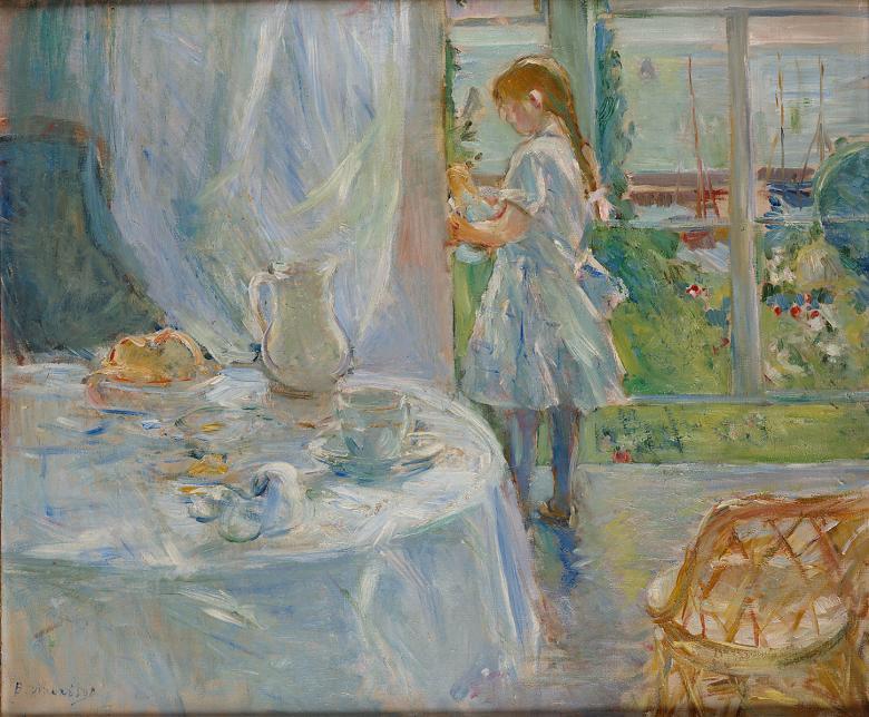 In the foreground, a round table with white tablecloth is set before a window. A young girl in a white dress holding a doll stands beside the window which reveals a view of a green lawn leading down to a jetty with sailboats. 