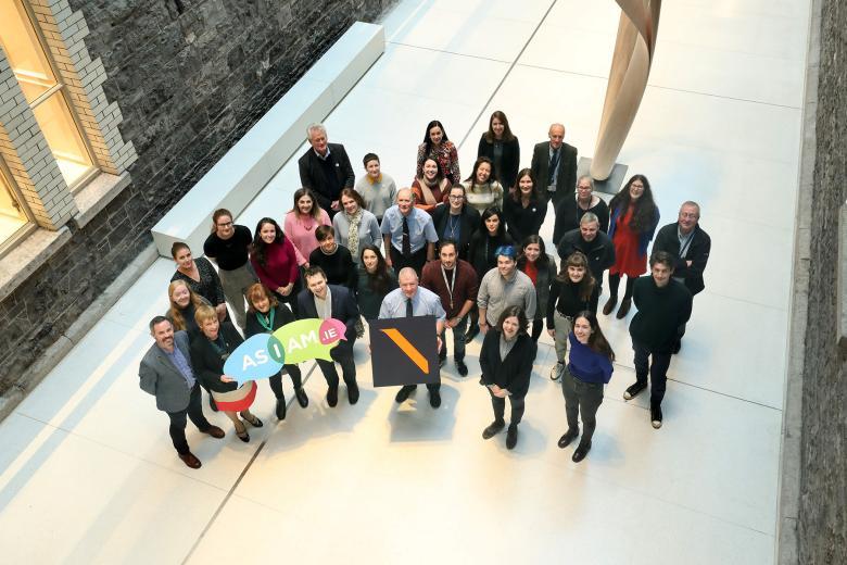 A group of gallery staff stand in the courtyard, smiling and looking up at the camera. 