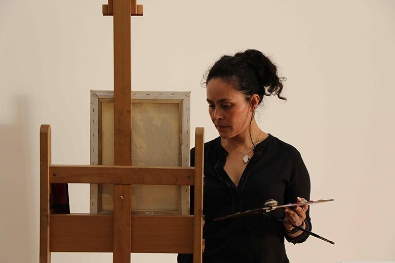 A woman painting at an easel