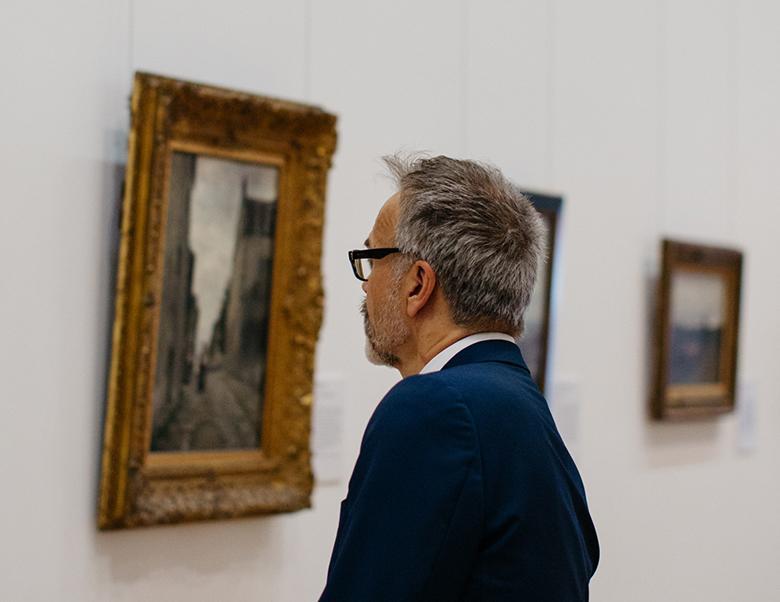 Man looking at a painting in the Millennium Wing of the National Gallery of Ireland.