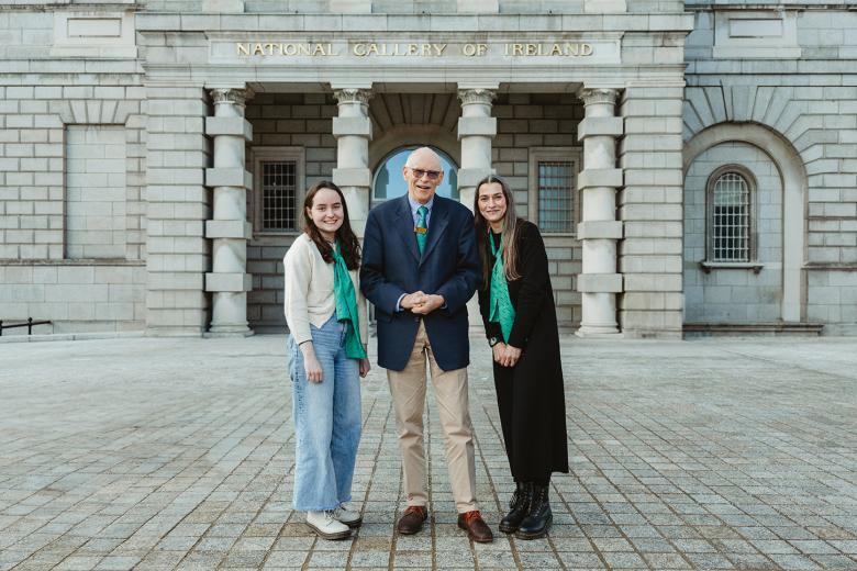 Three people stand on the forecourt of the Gallery, in front of the Merrion Square entrance.