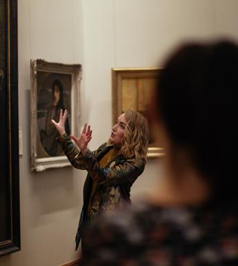 A tour guide speaking speaking about a painting