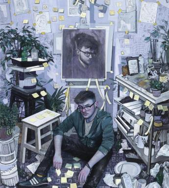 View of an artist's studio with a man wearing glasses seated on the floor in front of an easel with a self-portrait. Artist materials and sketches and plants surround him.