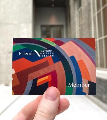 Photograph of a brightly coloured card with an abstract pattern being held up in a grey brightly light room