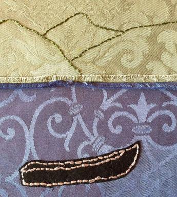 Photo of textile art showing a currach and mountains embroidered on cloth.