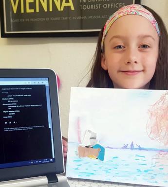 Child holds a hand drawn painting inspired by Monet