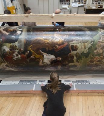 Members of the National Gallery of Ireland's conservation team rolling 'The Marriage of Strongbow and Aoife' in preparation for its move.