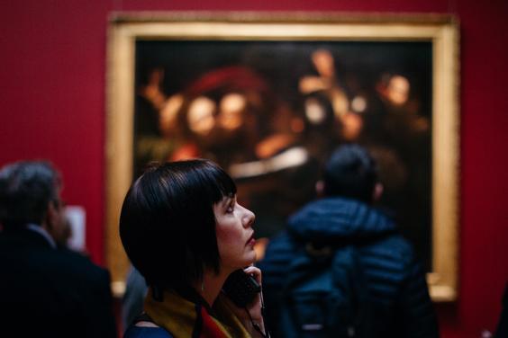 A visitor to Beyond Caravaggio examines a painting. © National Gallery of Ireland.