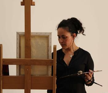 A woman painting at an easel